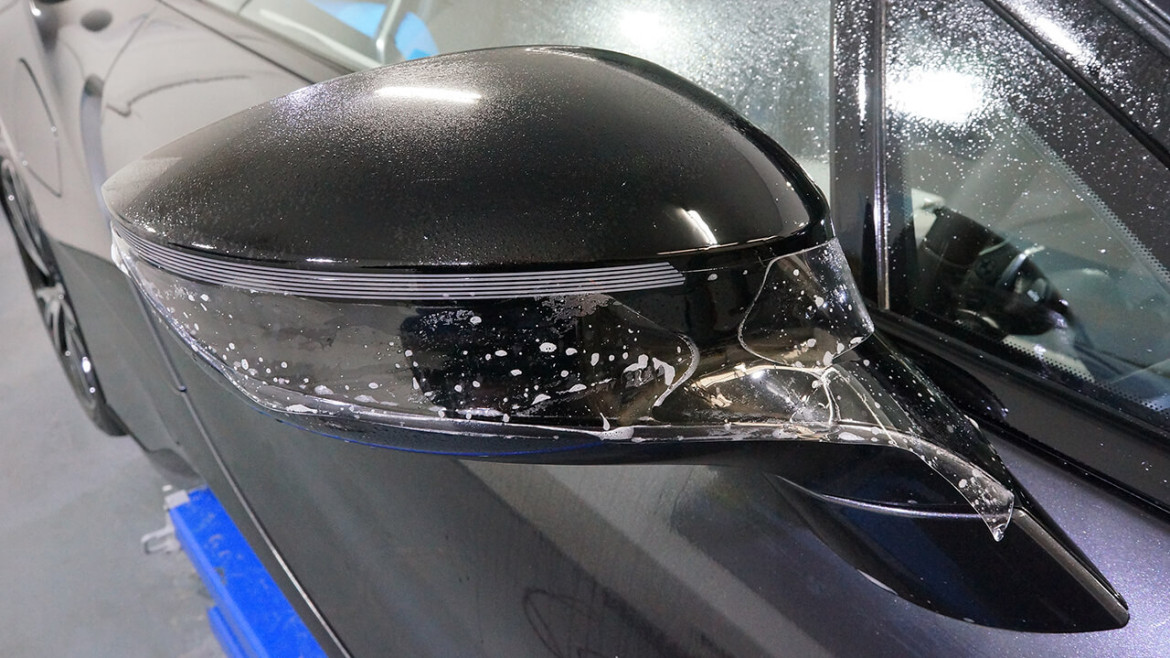 XPEL film being fitted to the mirror cap of a BMW i8