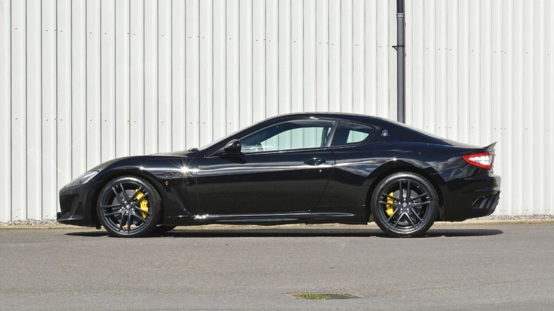 Side profile of the black Maserati GranTurismo MC Stradale after machine polishing