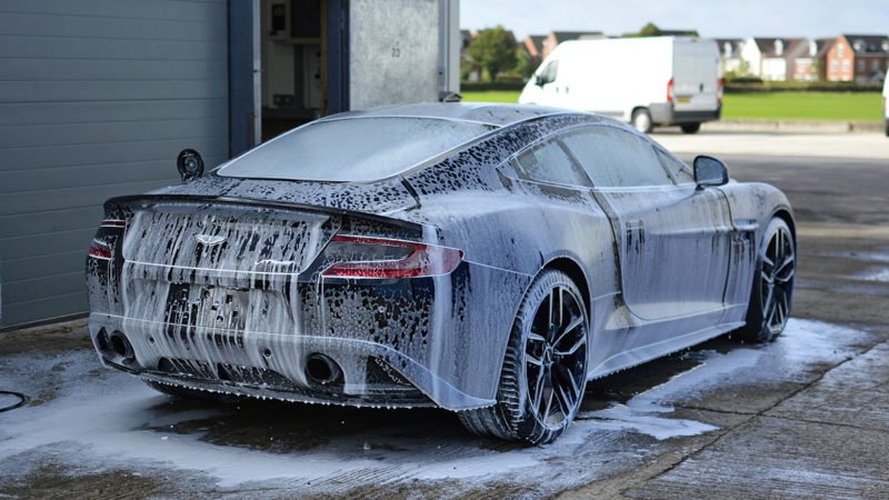 Aston Martin Vanquish Carbon Edition covered in snow foam during the wash stage