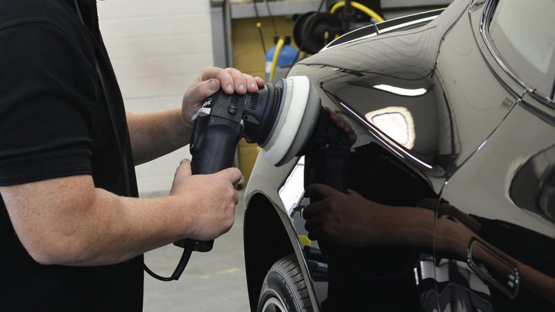 Rear quarter of the Aston Martin Vanquish being machine polished