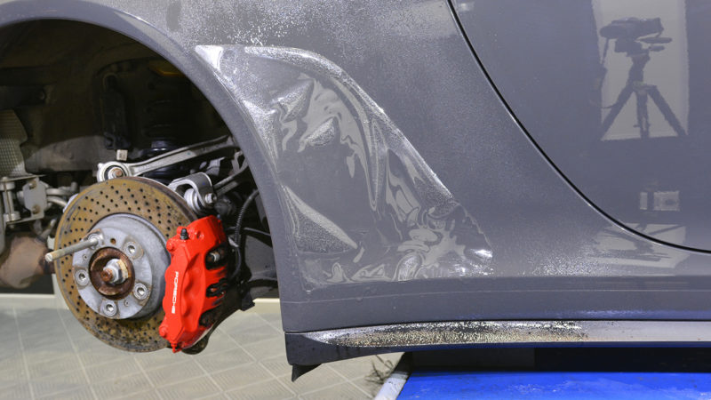 Front wheel removed from the Porsche 911 50th Anniversary exposing the red caliper and cross-drilled disc