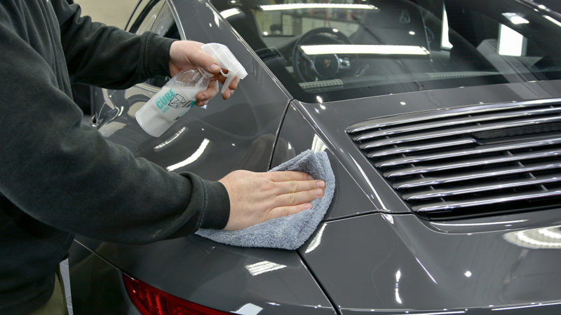Coating being sprayed and buffed over the rear deck of the Porsche 911 50th Anniversary