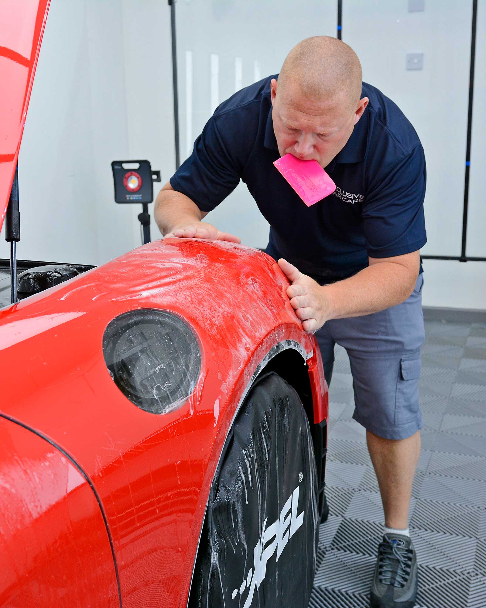 PPF being applied to the front wing of a Porsche GT4
