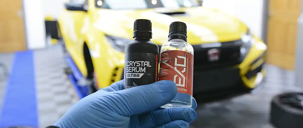 Gtechniq Crystal Serum Ultra and EXOv5 bottles held up in the Exclusive Car Care studio