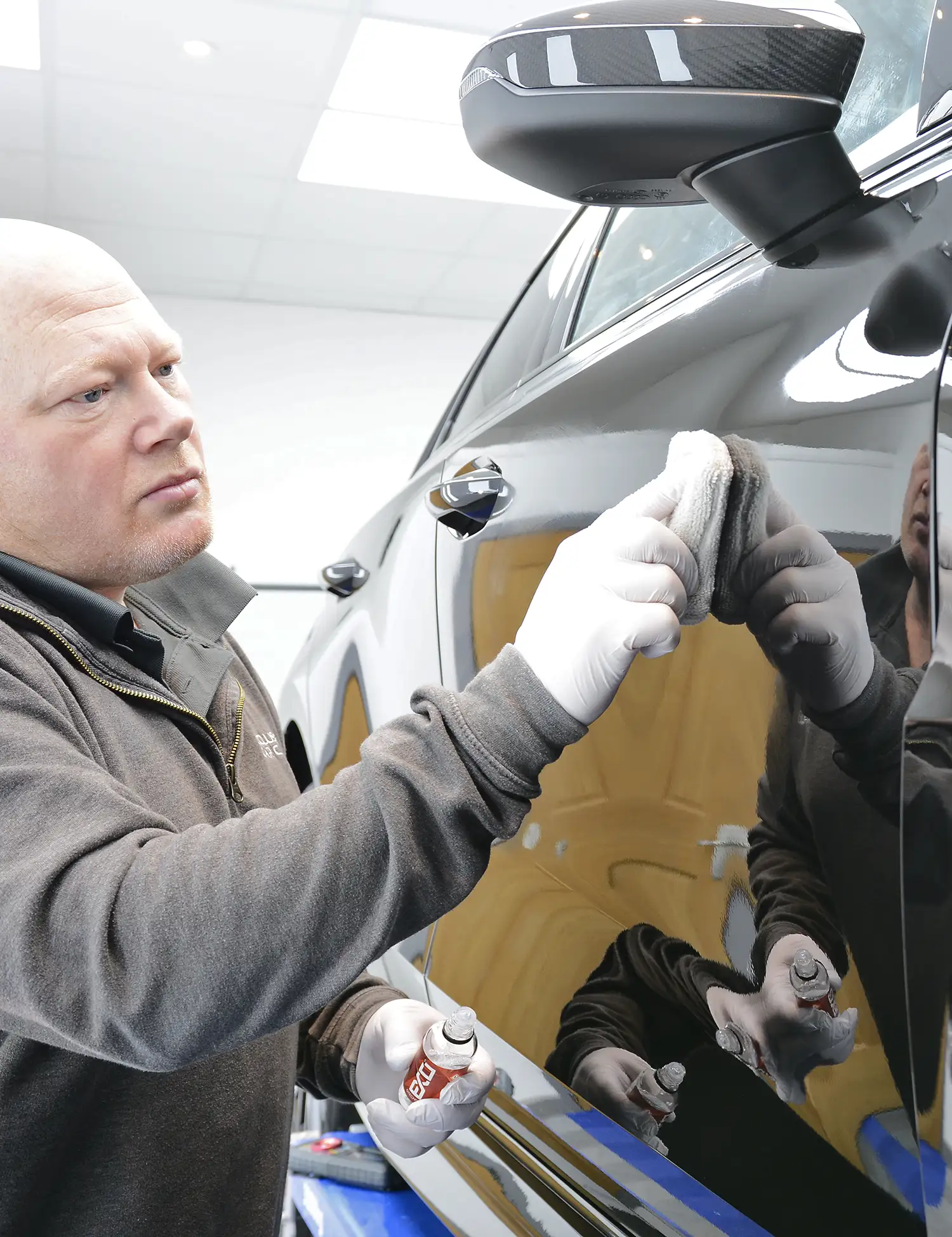 Gtechniq ceramic coating being applied by hand indoors at the Exclusive Car Care studio