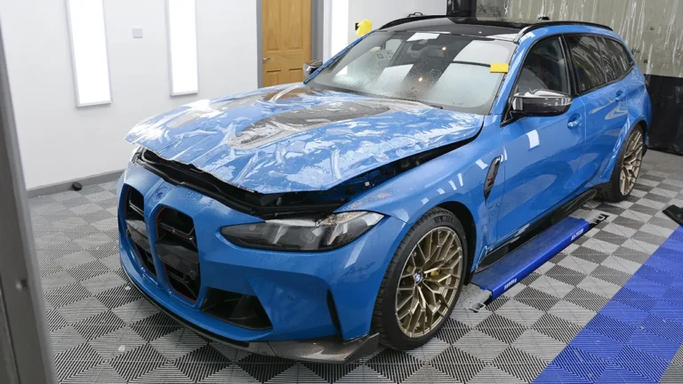 Laguna Seca Blue BMW M3 CS Touring with XPEL paint protection film being applied to the front end