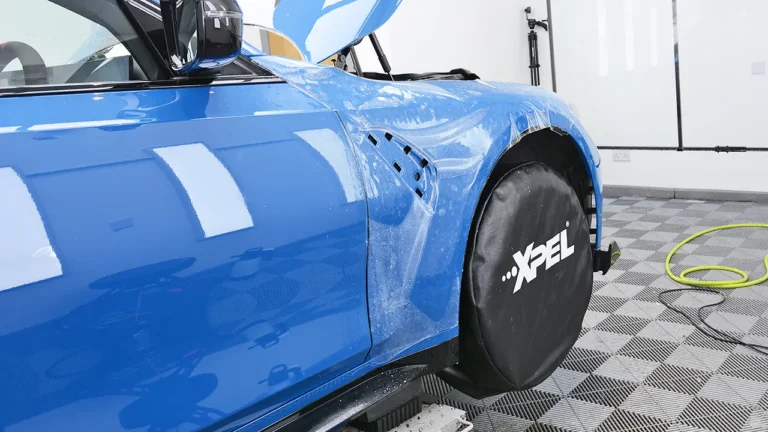 Front wing and door of the Laguna Seca Blue M3 CS Touring during wet application of XPEL film