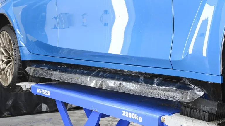 Side sill of the Laguna Seca Blue M3 CS Touring wrapped in paint protection film on the ramp