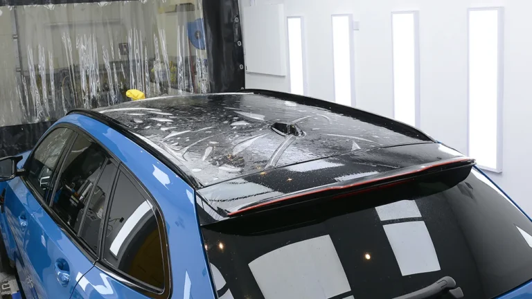 XPEL paint protection film laid over the roof of the Laguna Seca Blue M3 CS Touring ready to be squeegeed