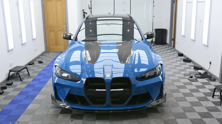 Head-on view of the Laguna Seca Blue M3 CS Touring showing the carbon bonnet vents under PPF