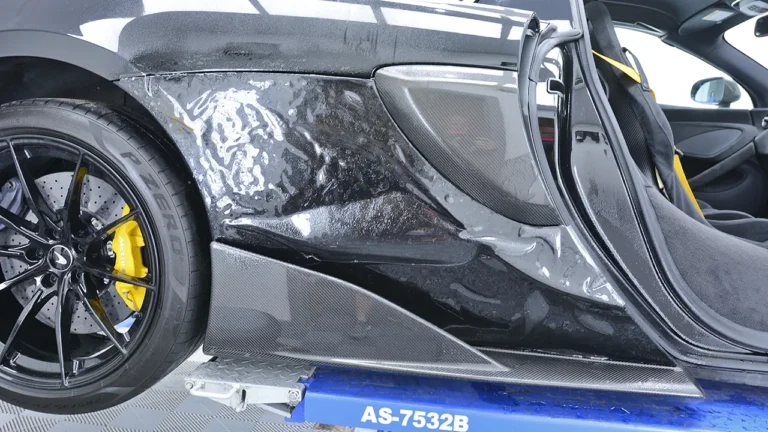 Side sill and lower door of the McLaren 600LT being covered in PPF on the ramp
